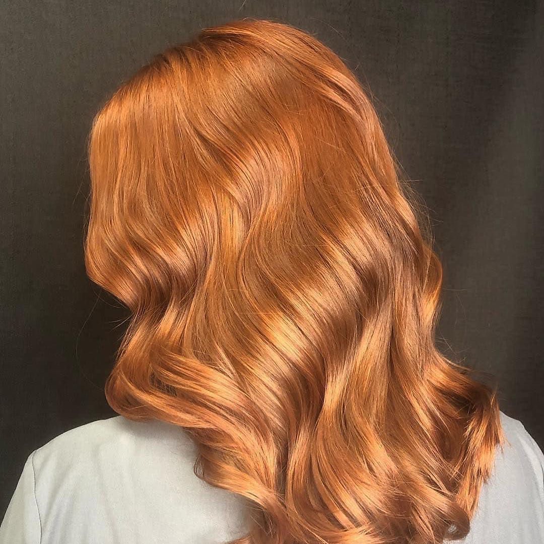 Vibrant copper hair colour styled in glossy soft waves