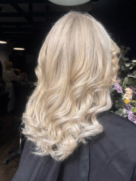 Creamy platinum blonde hair styled in loose curls